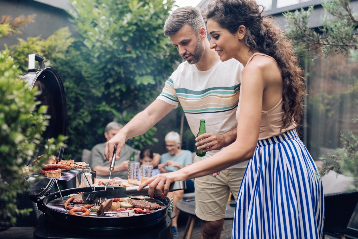 Mid adult couple preparing barbecue for the whole family at the backyard.